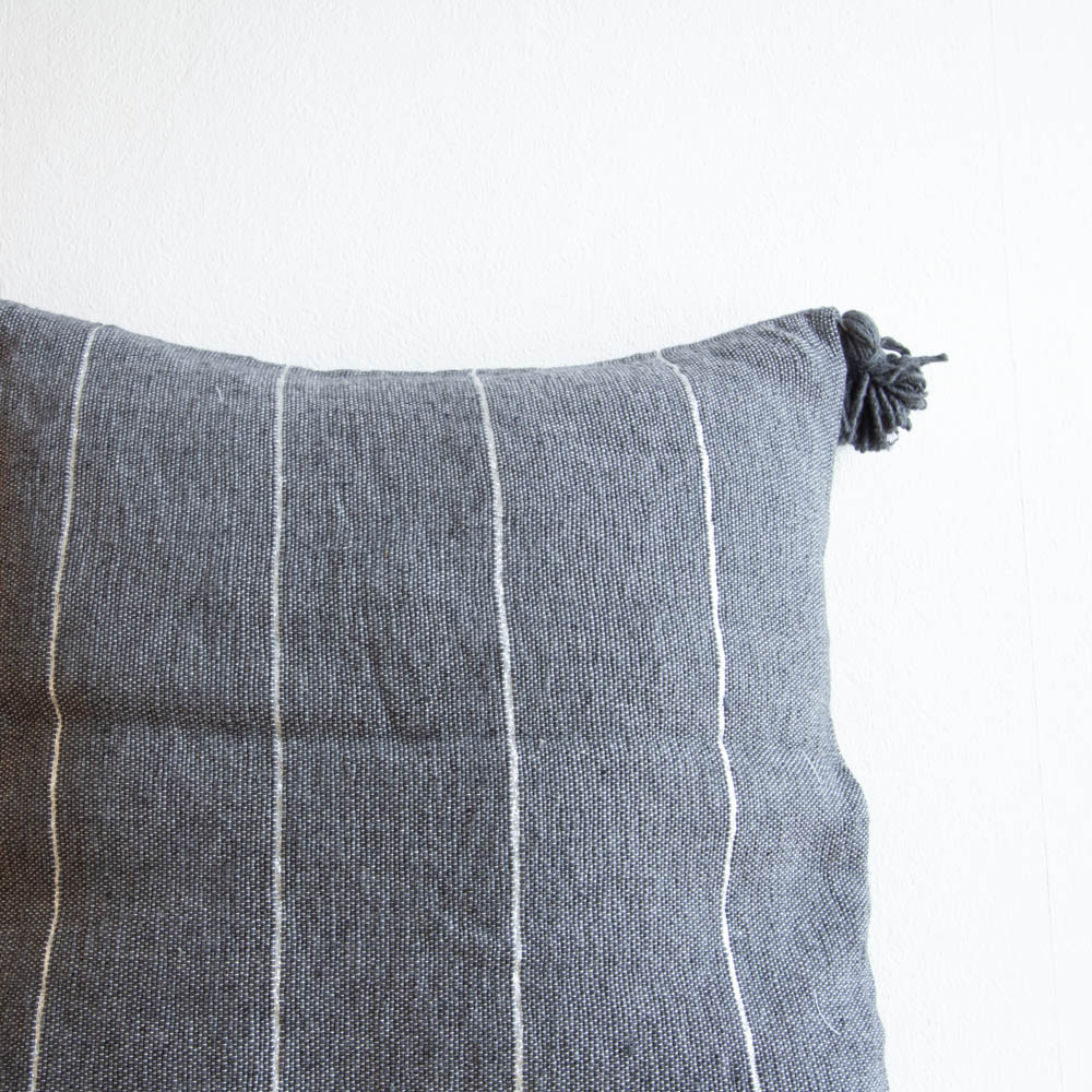 Graues Pompom Kissen mit Silberstreifen Graues Pompom Kissen mit Silberstreifen
