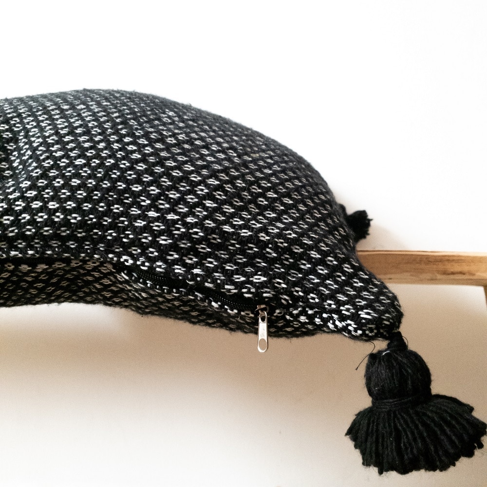 Handgewebtes weiร schwarzes Pom pom Kissen Handgewebtes weiร schwarzes Pom pom Kissen