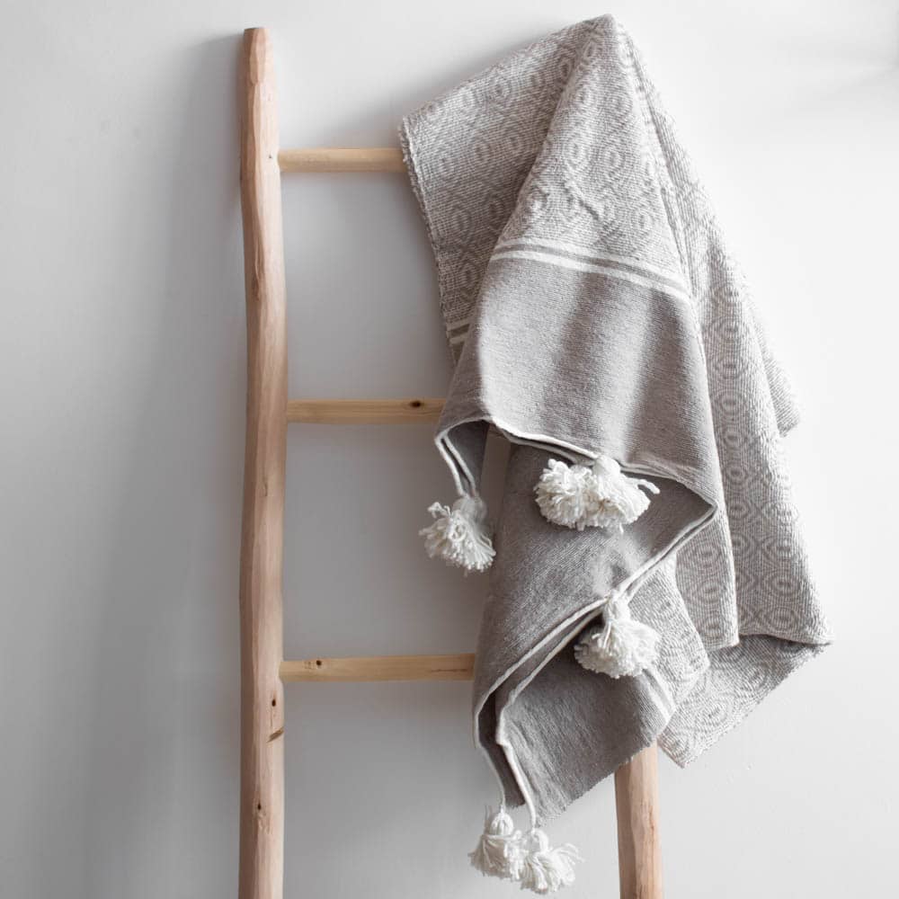 Gemusterte Pompom Decke in sand-weiß